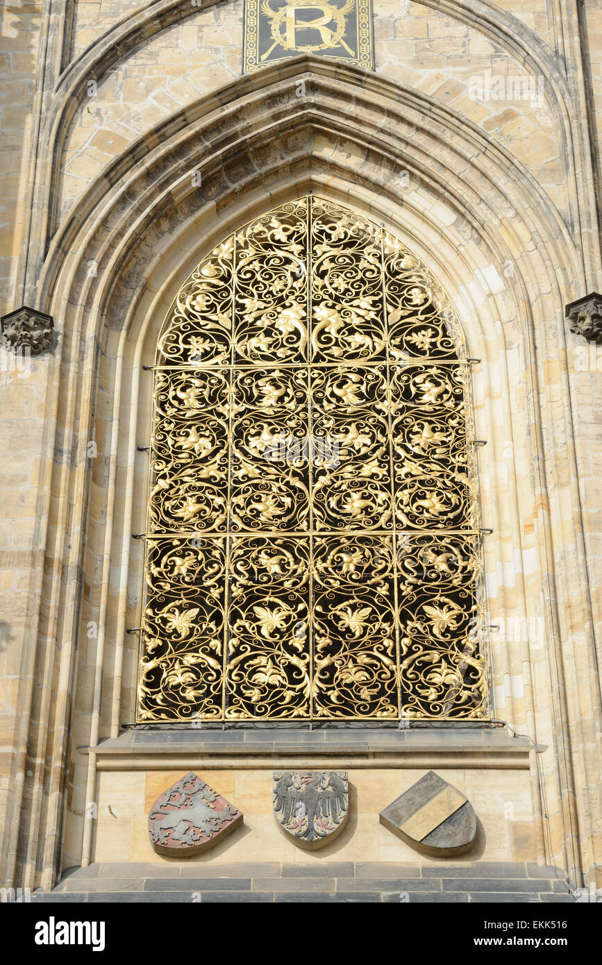 Exterior view of wrought gilded lattice of window in lancet pointed arch of the second tier of sought tower of St. Vitus Cathedr Stock Photo