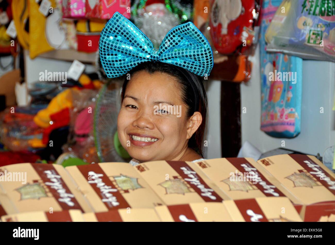 Ayutthaya, Thailand:  Smiling woman with a big blue hair bow in her booth at the Ayutthaya Floating Market Stock Photo