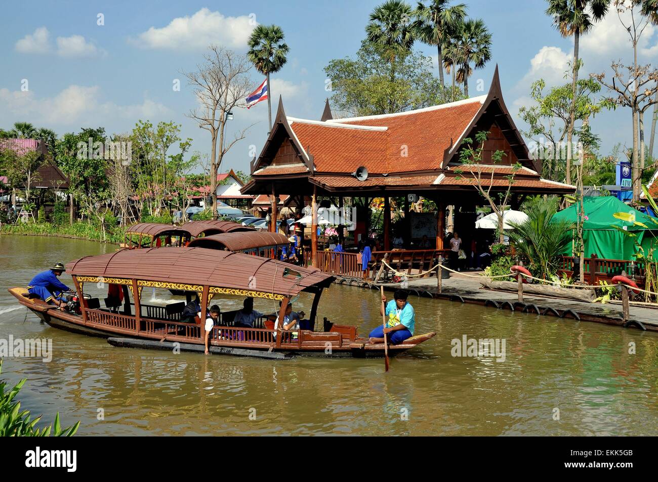 Ayutthaya, Thailand:  Boatmen fore and aft guiding a wooden touring boat along a klong (canal) at the Ayutthaya Floating Market Stock Photo