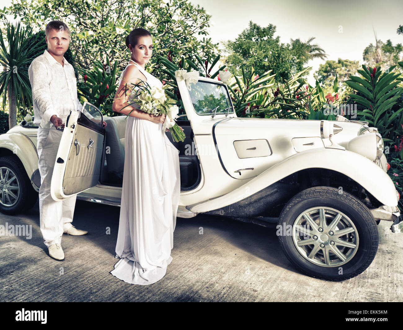 Bride and groom near the retro car Stock Photo - Alamy