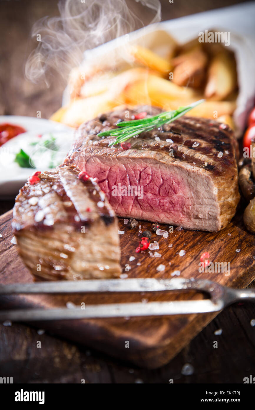 Delicious beef steak on wooden table, close-up Stock Photo