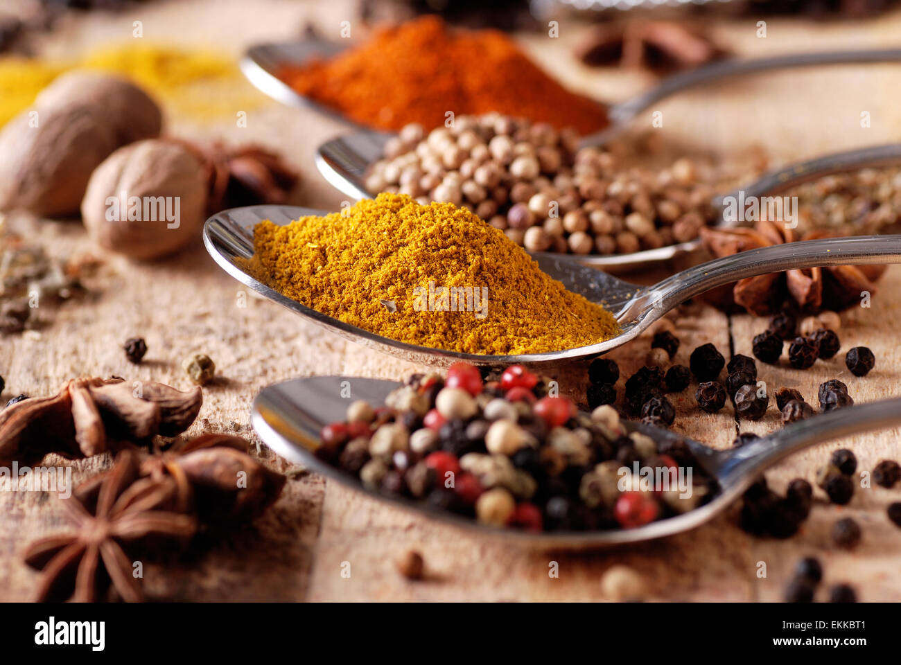Assorted spices in metal spoon Stock Photo