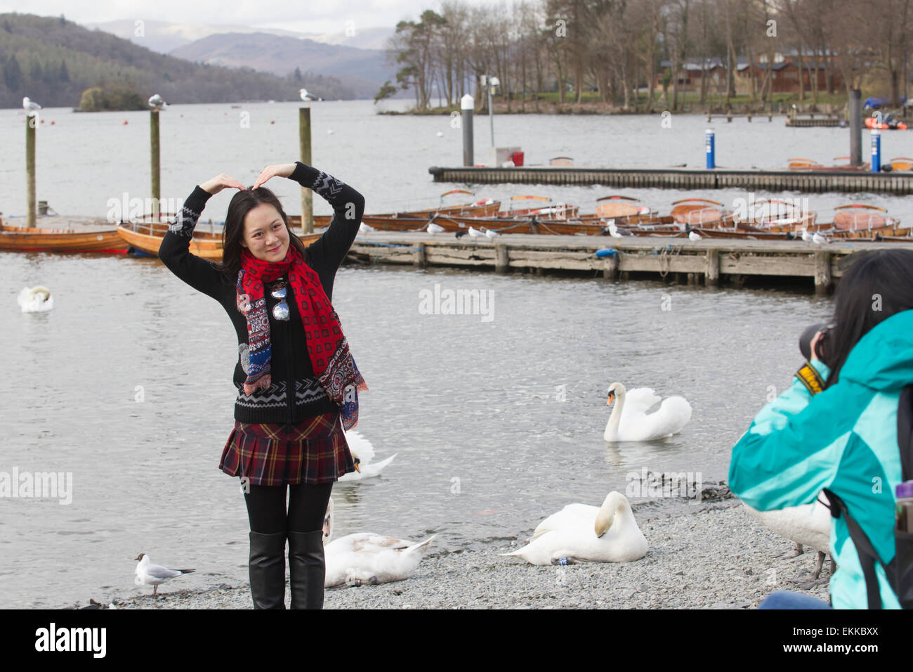 Lake Windermere Cumbria  11th April 2015 UK Weather Chinese tourists make the most of cold windy day posing for souvenir photos by the lake at Bowness Bay on Lake Windermere  Credit:  Gordon Shoosmith/Alamy Live News Stock Photo