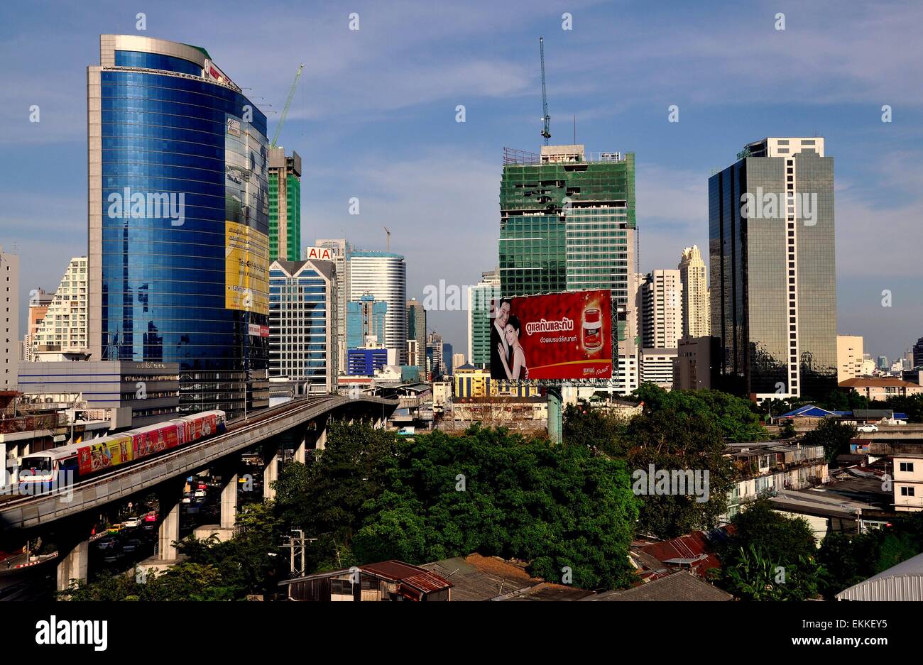 Bangkok, Thailand:  A Silom Line SKYTRAIN on its elevated tracks with modern corporate office towers on Sathorn Road Stock Photo