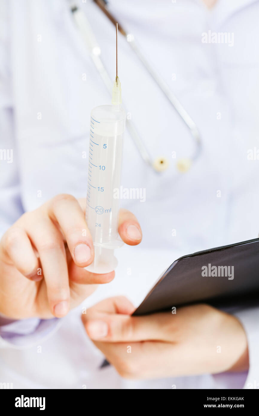 nurse holds syringe and clipboard close up Stock Photo - Alamy