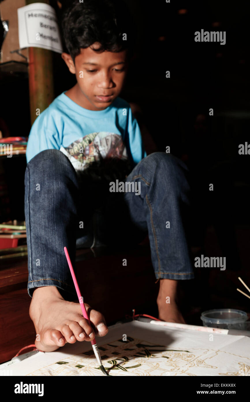 SALWA ARIS TOTEL, a student from Disbality School YPAC-Surakarta-MidJava paint with his pair of foot to replace his disability arm. According to his teacher, Mrs. Endang Murtiningsih, SALWA is a multi talented person, beside painting he also can play organ. Salwa attend the Inacraft Exhibition (Indonesian Local Product Exhibition) at JHCC-Senayan Jakarta to present his paint work. Stock Photo