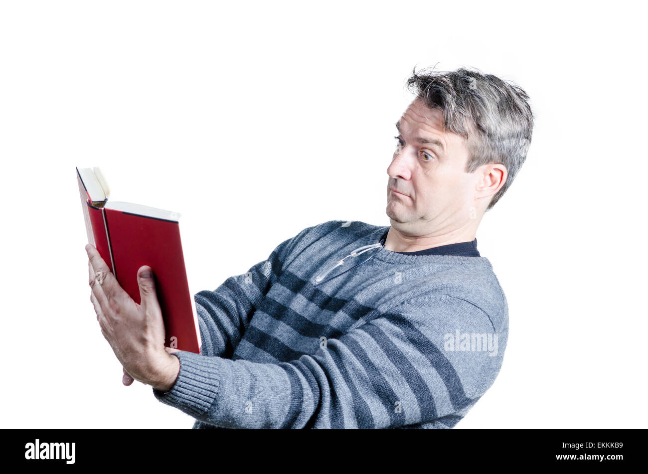 Guy finding holding a book at quite a distance to be able to read Stock Photo