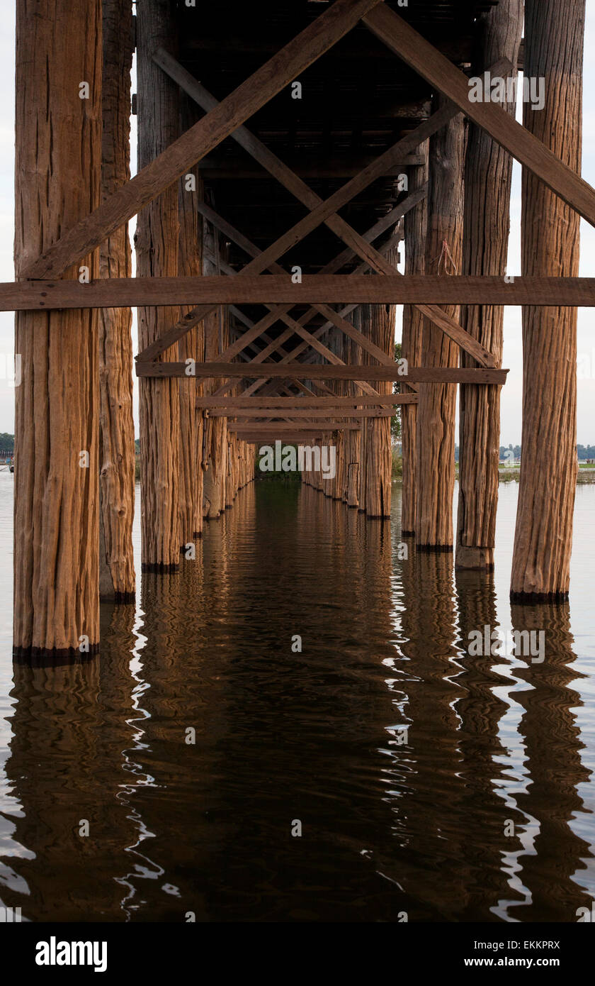 A perspective view of the U Bein Bridge from below,showing the teak timbers of its construction reflected in the ripples. Stock Photo