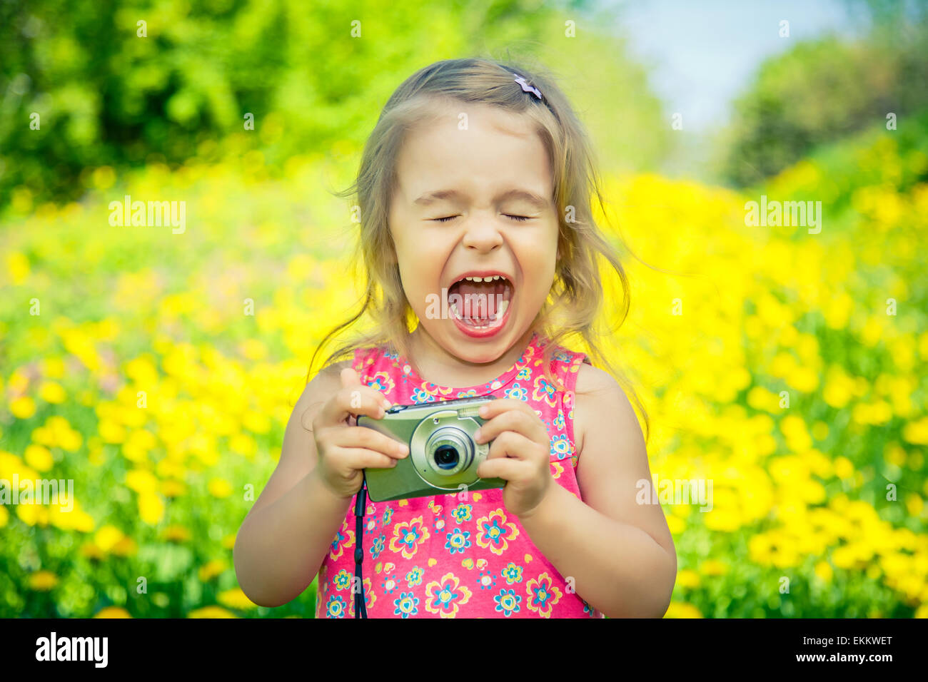 Little girl taking pictures on a meadow Stock Photo