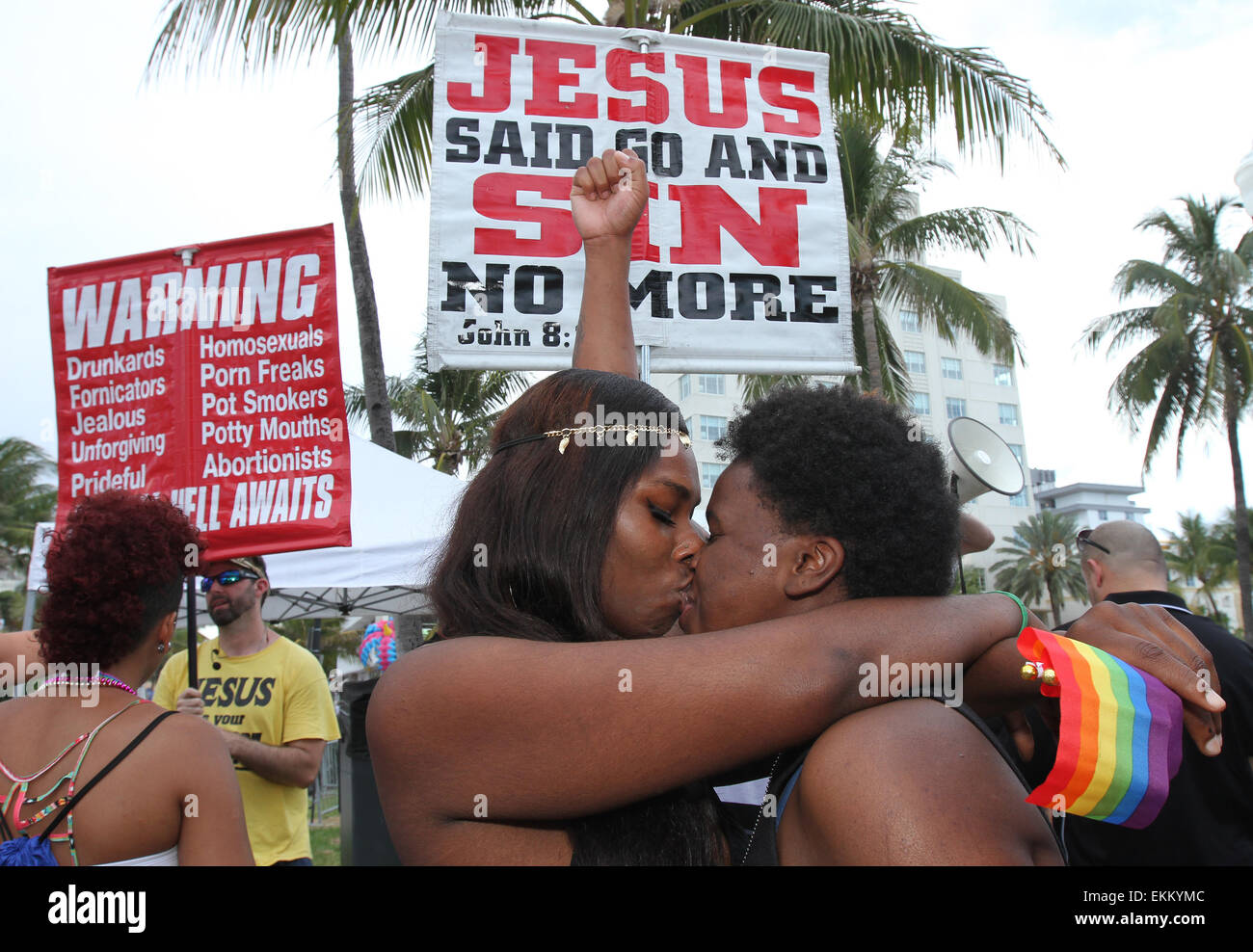 Miami Beach, Florida, USA. 11th April, 2015.  China Jackson (L) and Bookie Gaitor of Miami, kiss in front of members of Team Jesus Preachers who assembled near 12th Street on Ocean Drive with banners to admonish the gay lifestyle during the Miami Beach Gay Pride festival in Miami Beach, Florida on 11 April, 2015.  Credit:  Sean Drakes/Alamy Live News Stock Photo