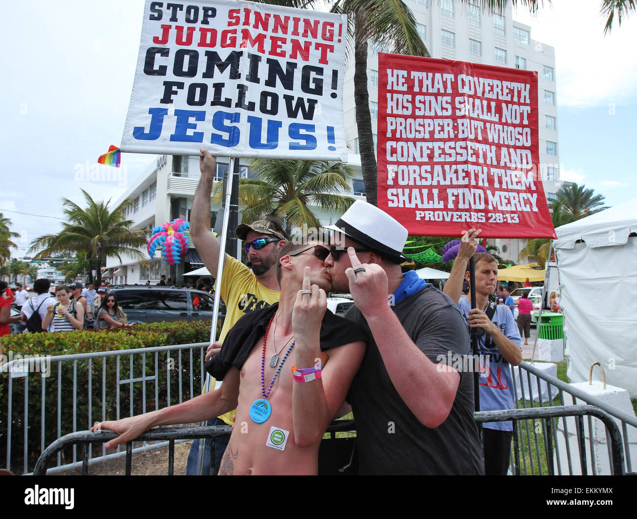 Miami Beach, Florida, USA. 11th April, 2015. Christopher Schultz (L) and Maxwell Finley of Westchester, New York, kiss in front of members of Team Jesus Preachers who assembled near 12th Street on Ocean Drive with banners to preach the teachings of the Bible and admonish the gay lifestyle during the Miami Beach Gay Pride festival in Miami Beach, Florida on 11 April, 2015.  Credit:  Sean Drakes/Alamy Live News Stock Photo