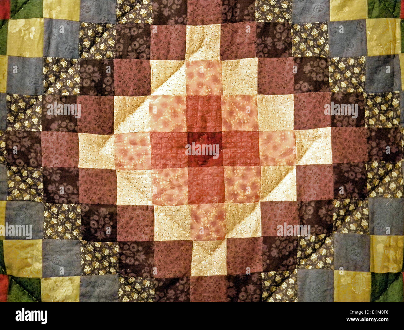 Close up of a brown calico handmade quilt. Stock Photo