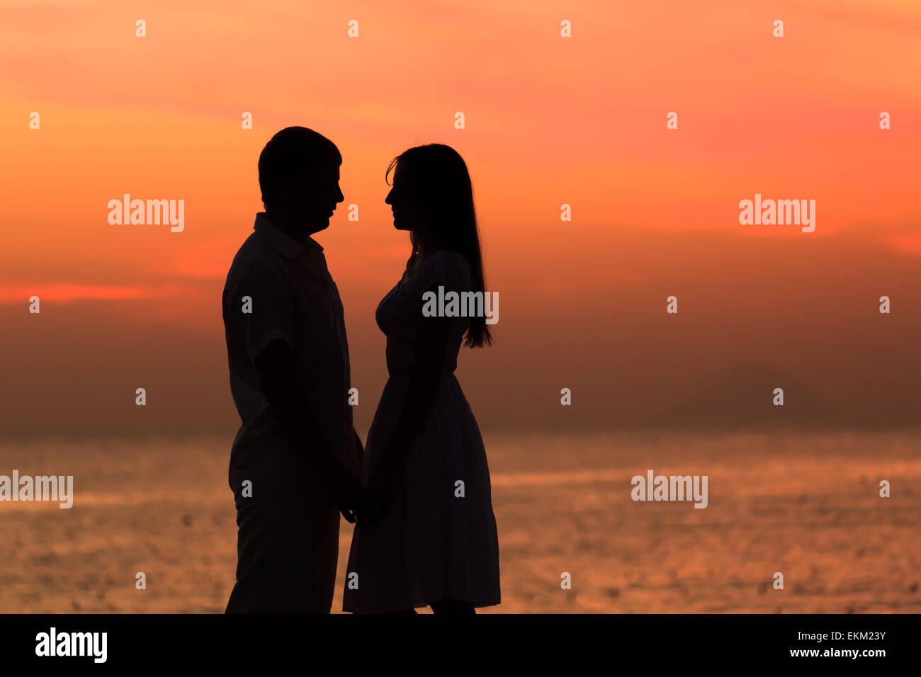 Couple silhouette at sunrise time. Ocean on background Stock Photo