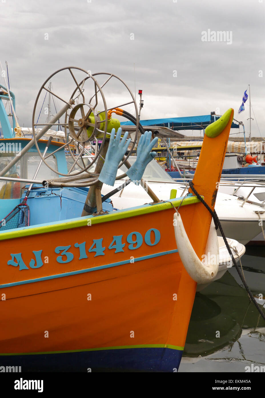 Rubber gloves drying on a blue and orange fishing boat in a harbour in Ajaccio Corsica Stock