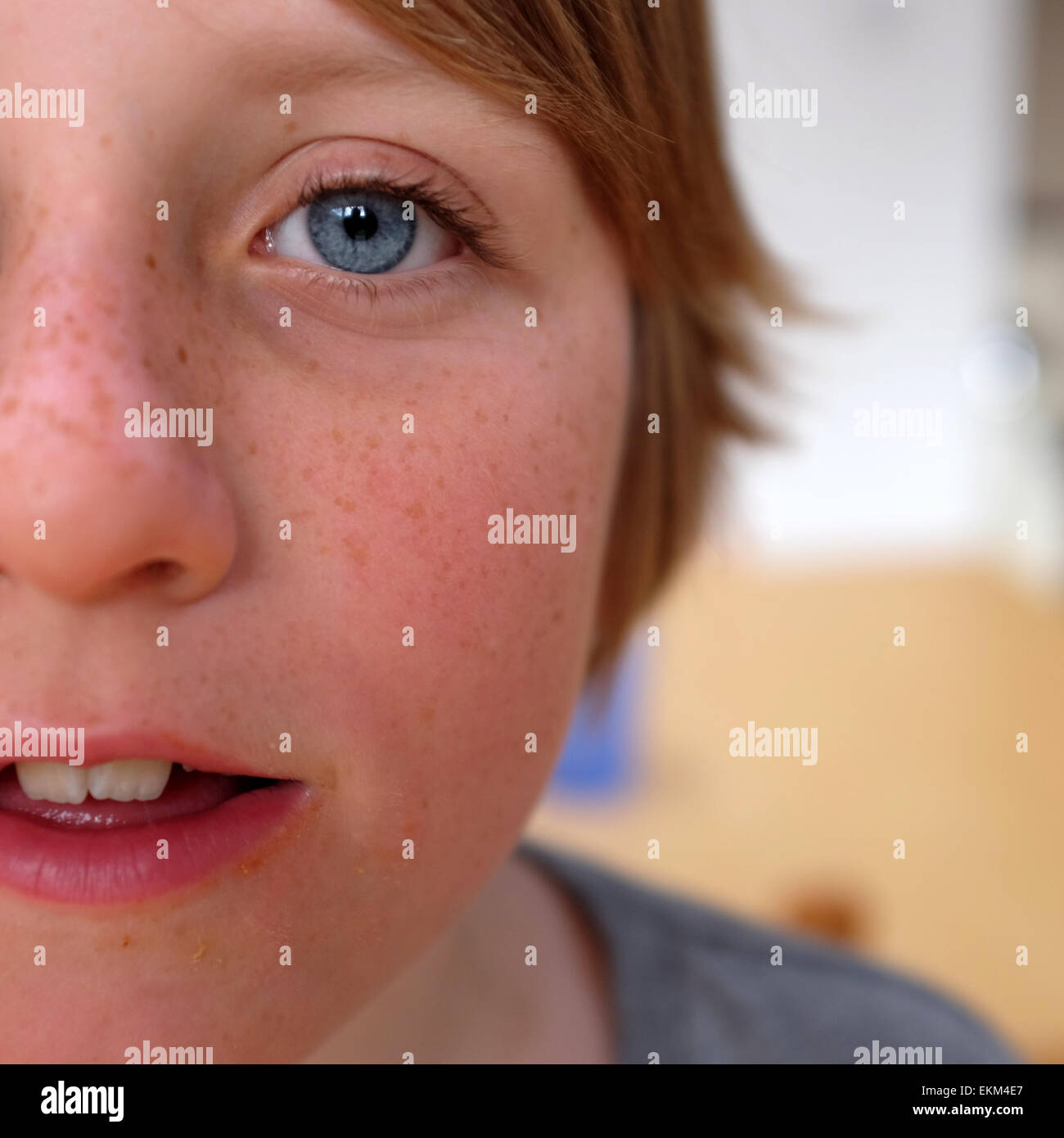 Close up portrait photo of boy with blue eyes and long hair against a blurred background Stock Photo