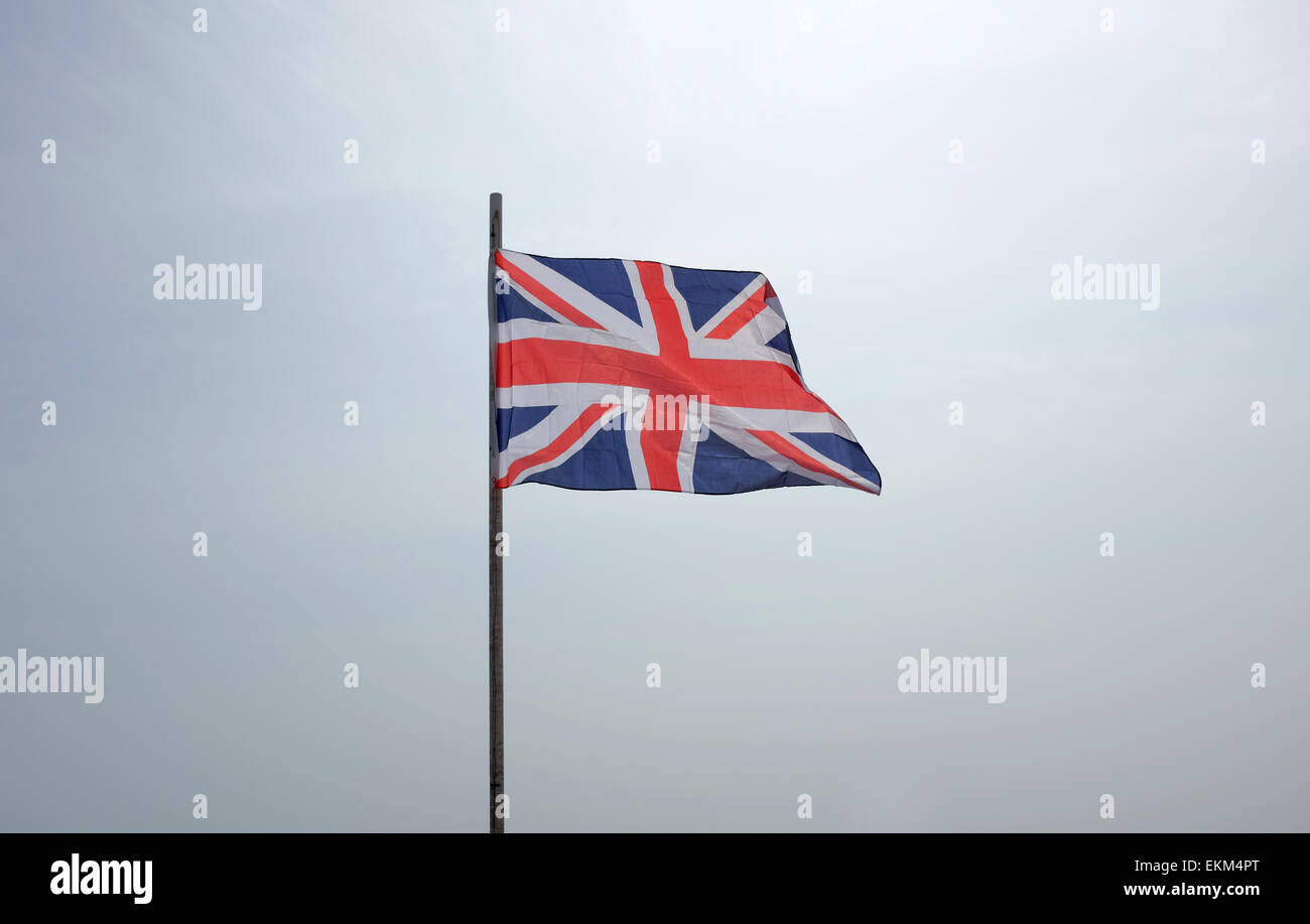 Union Flag flying against a white background sky Stock Photo