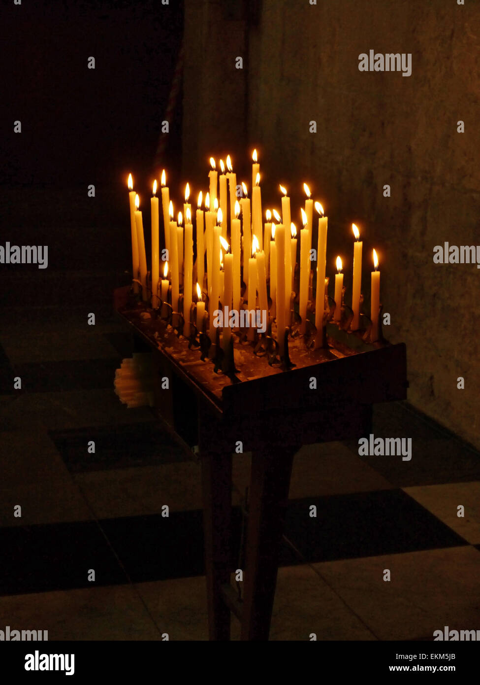 A candle holder in a church with lighted candles Stock Photo