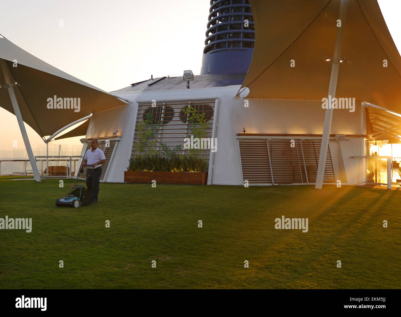 A man mowing the lawn on the deck of the cruise ship Celebrity Equinox. Stock Photo