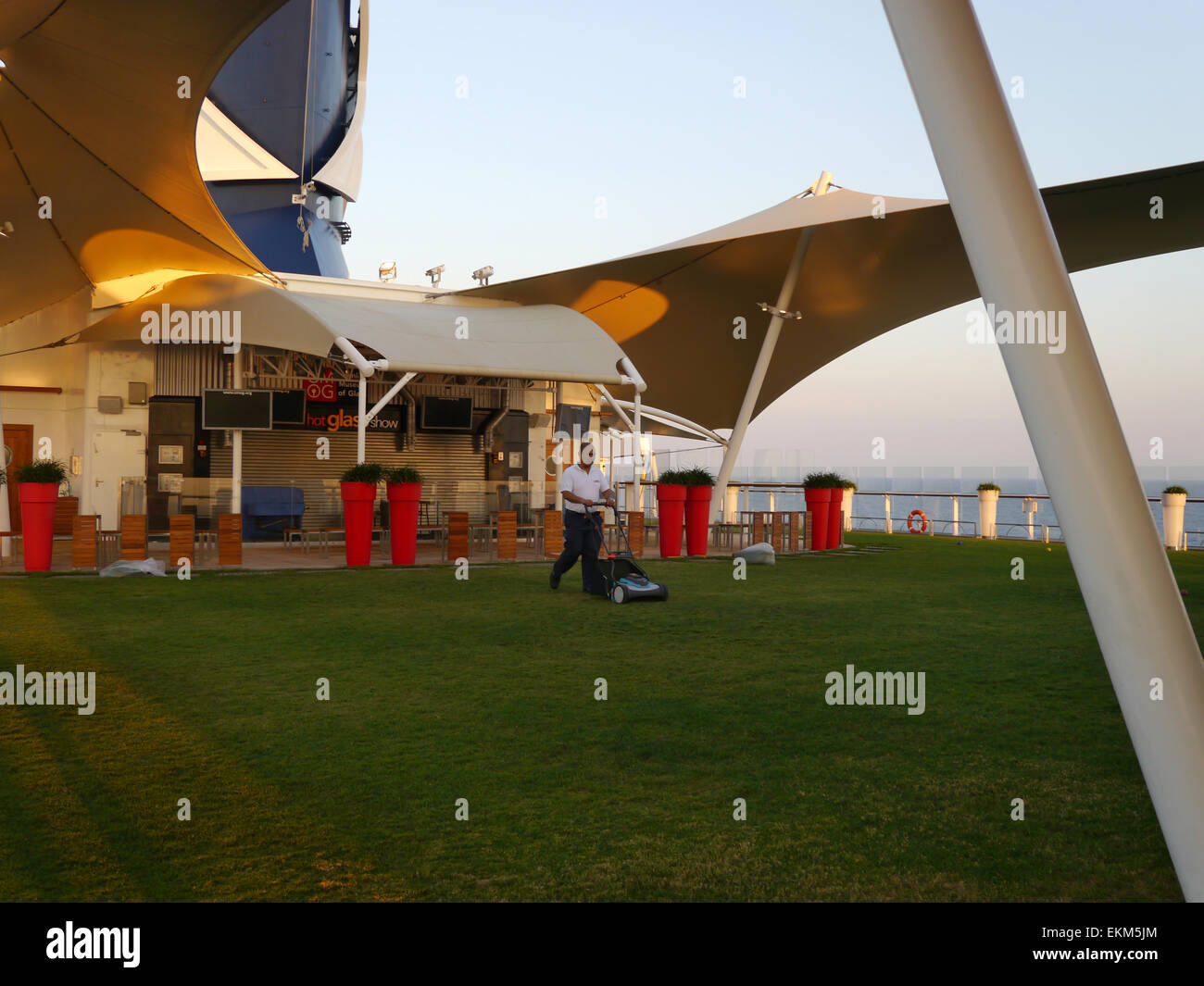A man mowing the lawn on the deck of the cruise ship Celebrity Equinox. Stock Photo