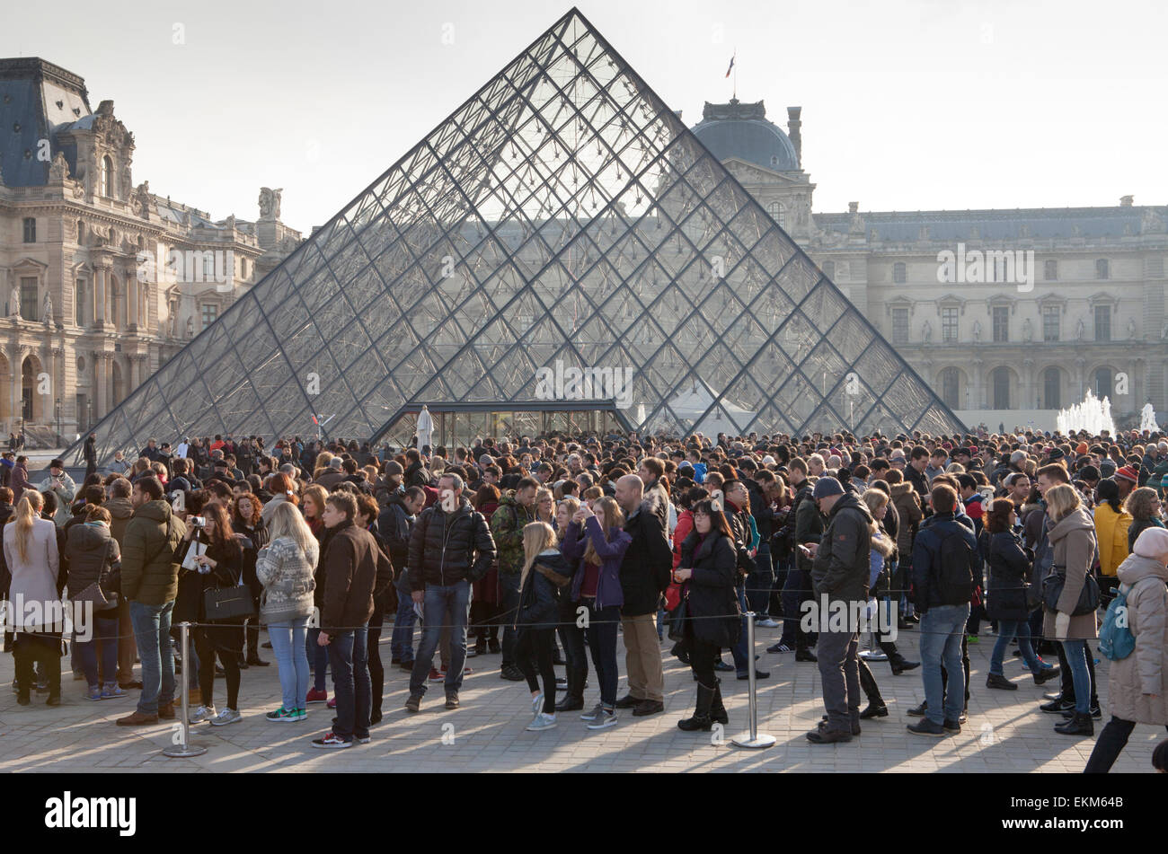 The queue of visitors at the Louvre Pyramid and Palace in Paris Stock