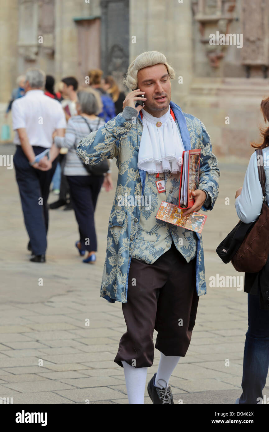 A concert ticket seller in period costume talking on a mobile telephone, Vienna, Austria. Stock Photo