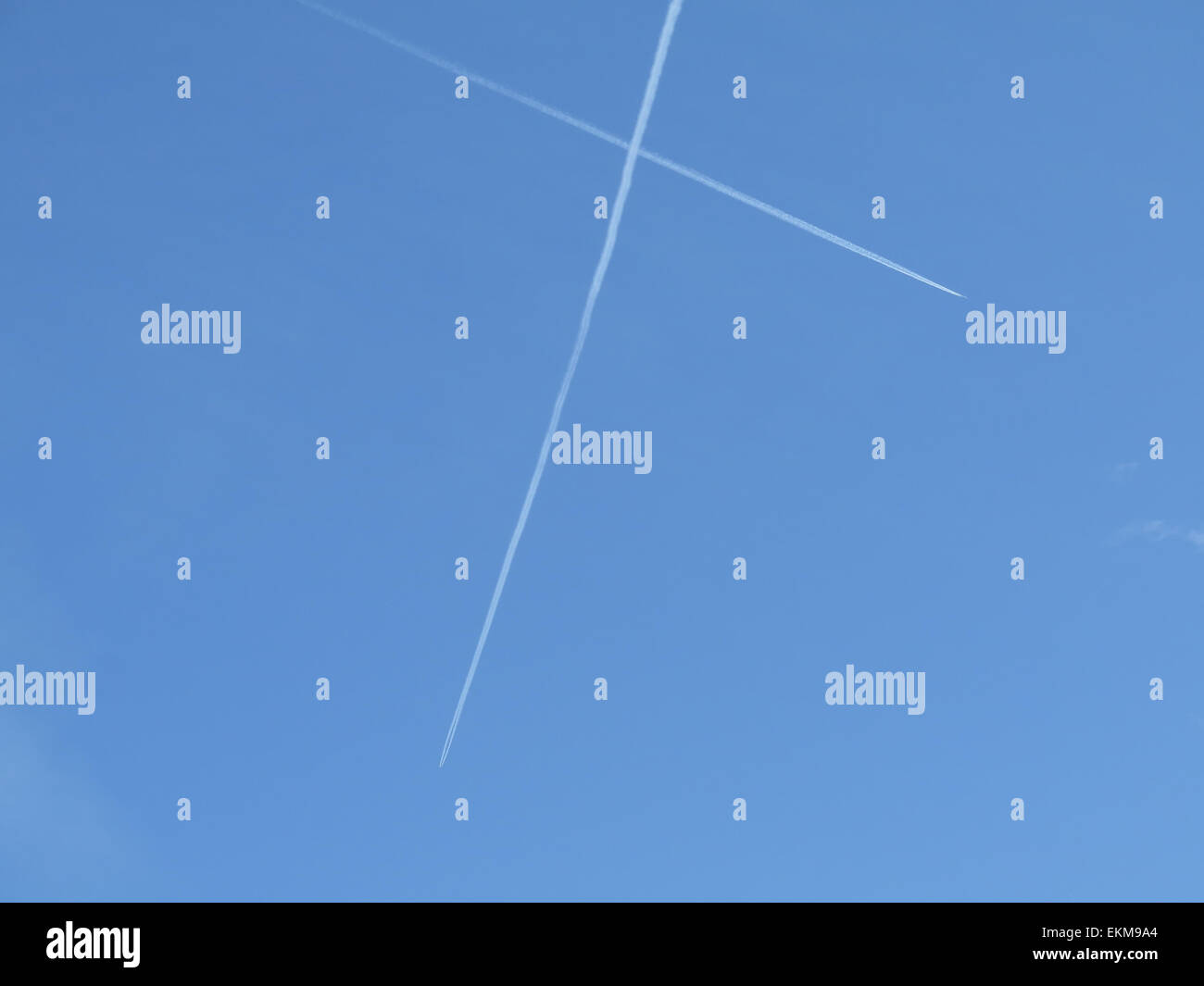 Jet contrails / vapour trails against a blue sky Stock Photo