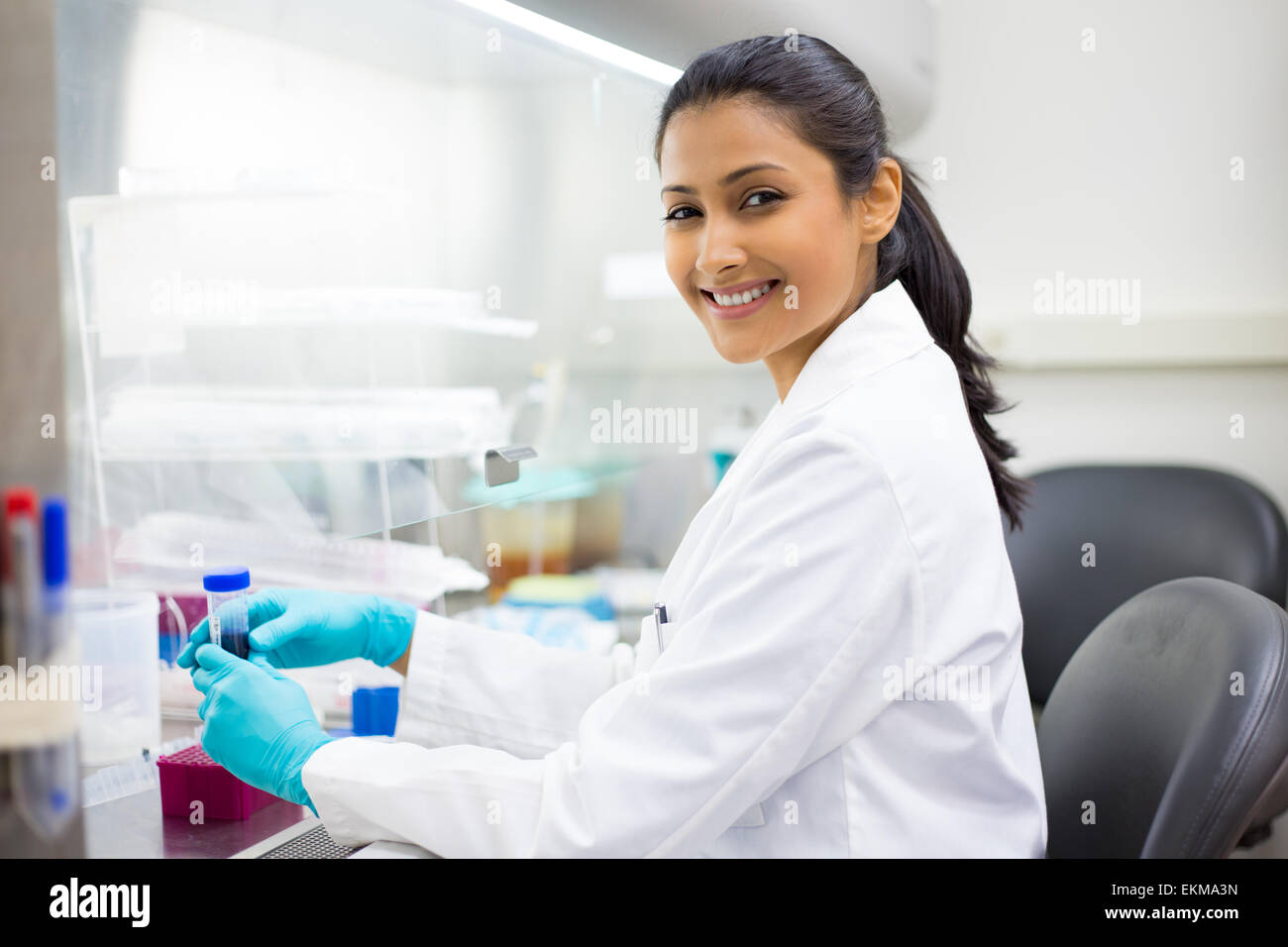 Closeup portrait, scientist holding 50 mL conical tube with blue liquid solution, laboratory experiments Stock Photo