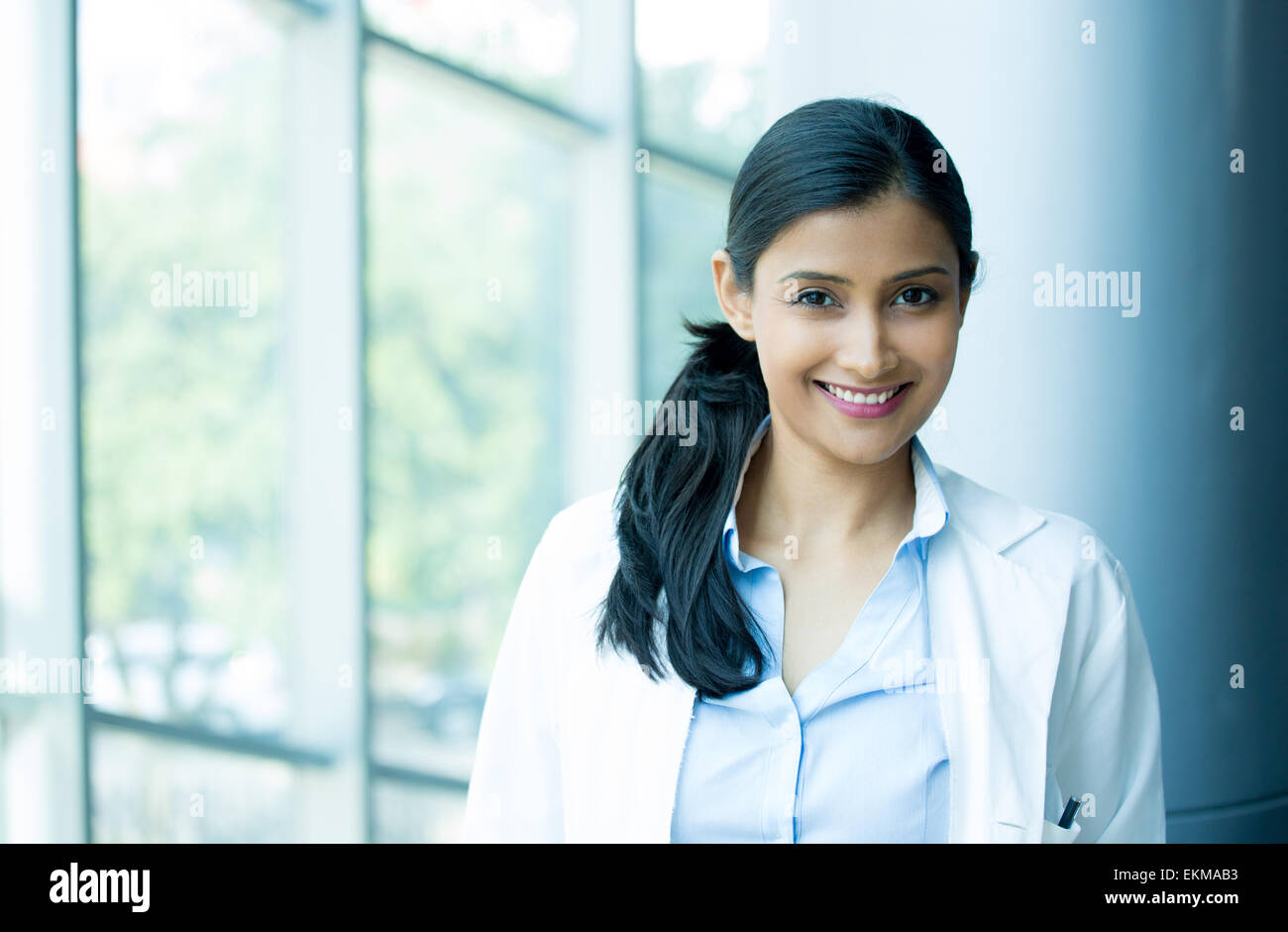 Closeup head shot portrait of friendly, cheerful, smiling confident female, healthcare professional with lab coat. Stock Photo