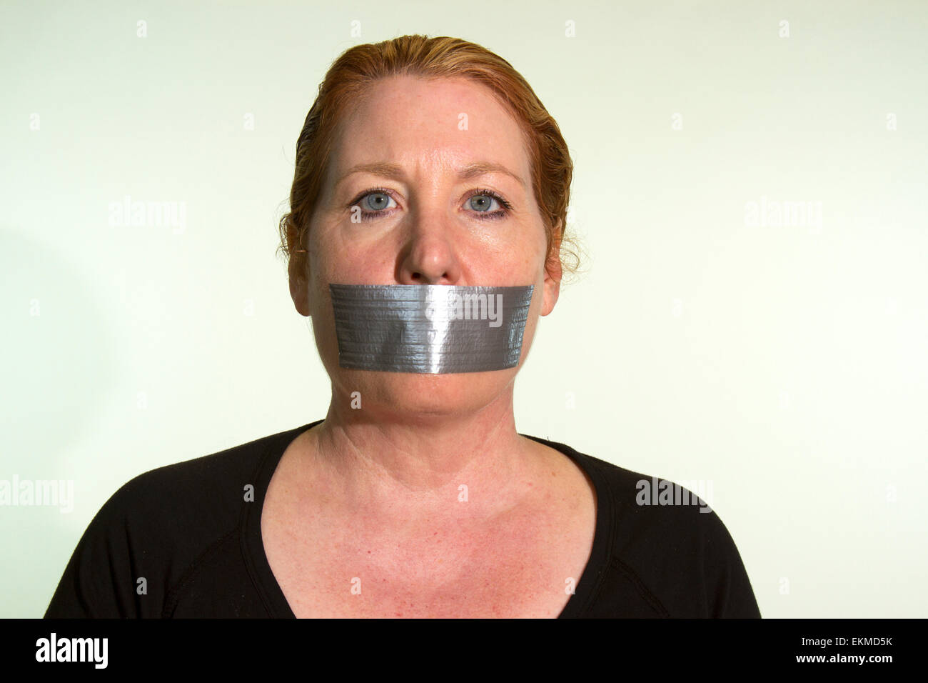 Censorship of  expression expressed by a woman with duct tape over her mouth Stock Photo