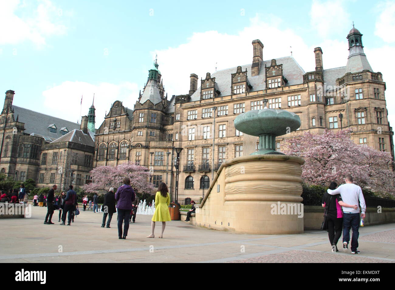 Pedestrians pass through Sheffield's Peace Gardens by the city's Town Hall (pictured), Sheffield, South Yorkshire,UK - spring Stock Photo
