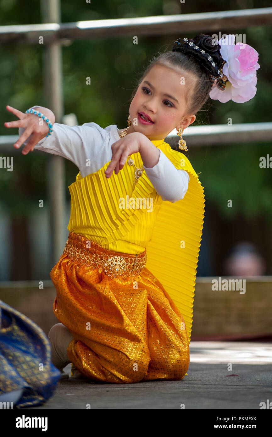 London, UK. 12 April 2015. A young girl perfoms a traditional dance on stage as part of the celebrations at Thai New Year (Songkran) at Buddhapadipa Temple in Wimbledon, the only Thai temple in the UK purposely built in the Thai architectural style. Guests took part in religious ceremonies, enjoyed Thai classical music and dancing performances, a Miss Songkran beauty pageant as well as stalls selling Thai food, groceries and souvenirs. Credit:  Stephen Chung/Alamy Live News Stock Photo