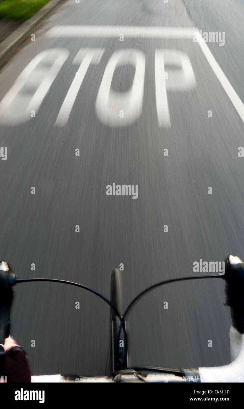Cycling towards STOP sign painted on road Stock Photo