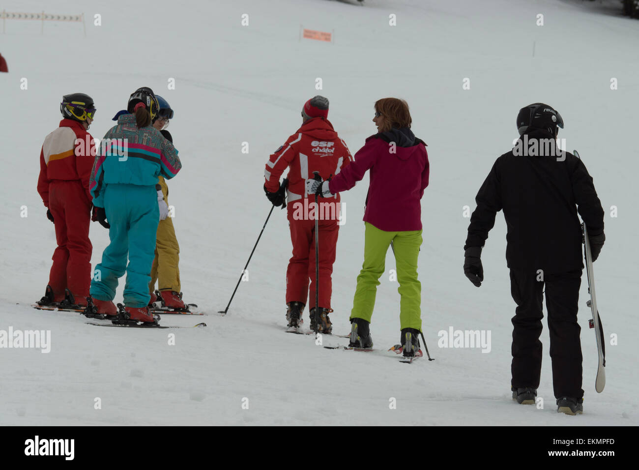 A pack of students being taught & learning how to ski down the alps by an instructor Stock Photo
