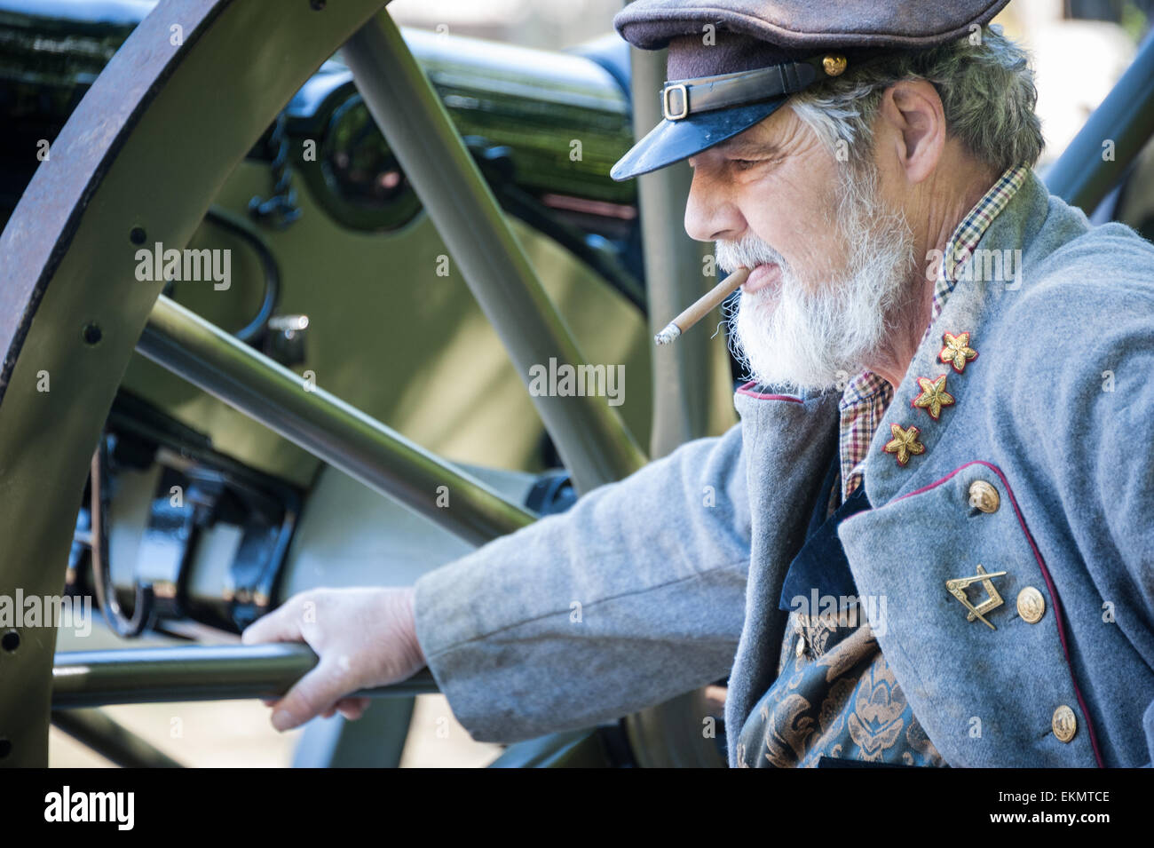 Confederate soldier reenactor resting upon a canon wheel at the National Confederate Memorial Day Observance at Stone Mountain. Stock Photo