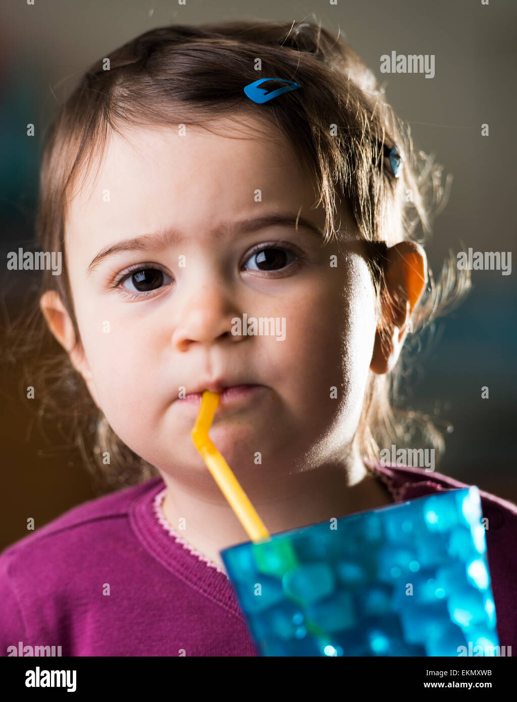 cute baby girl drinking with a straw Stock Photo Alamy