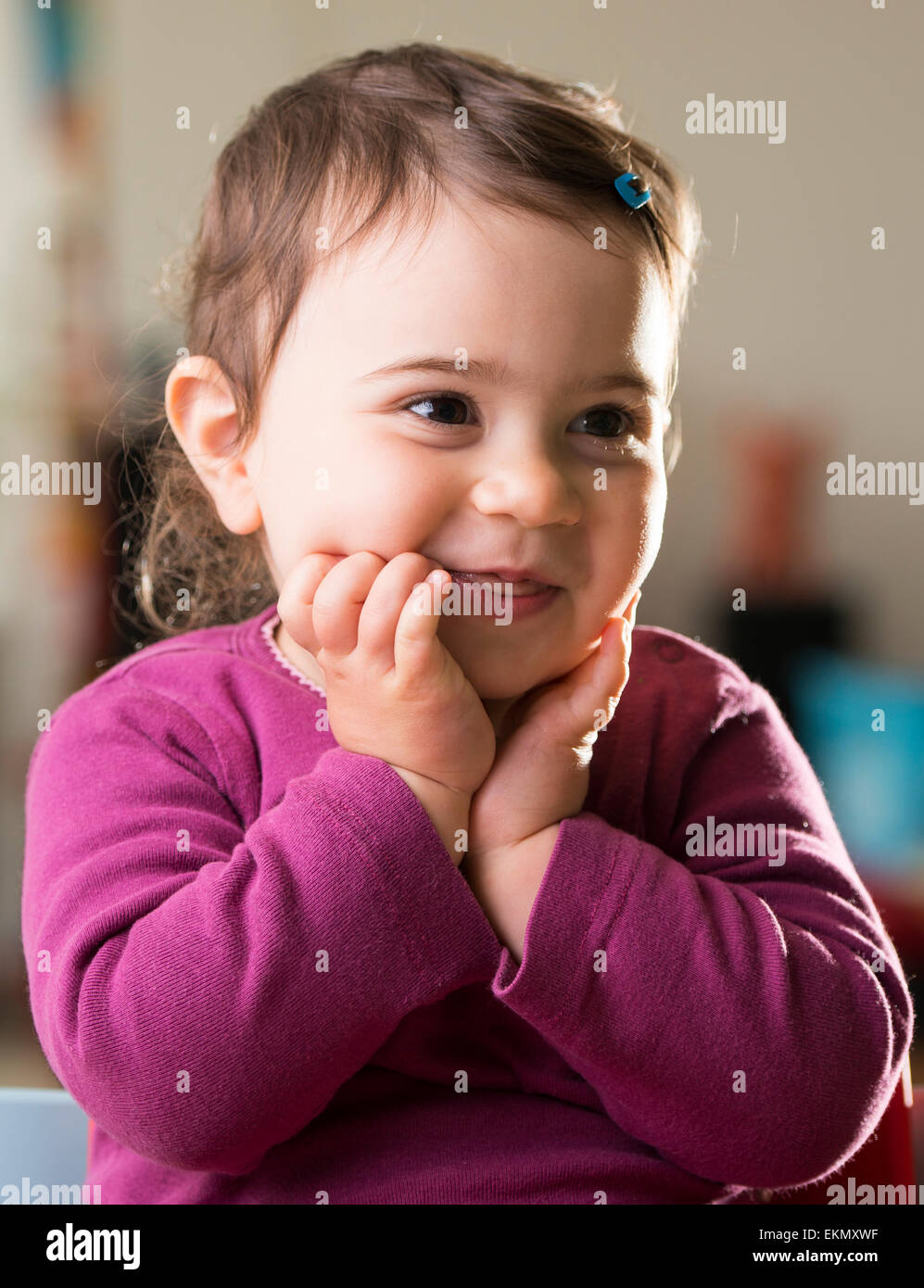 cute baby girl in purple looking aside laughing Stock Photo Alamy