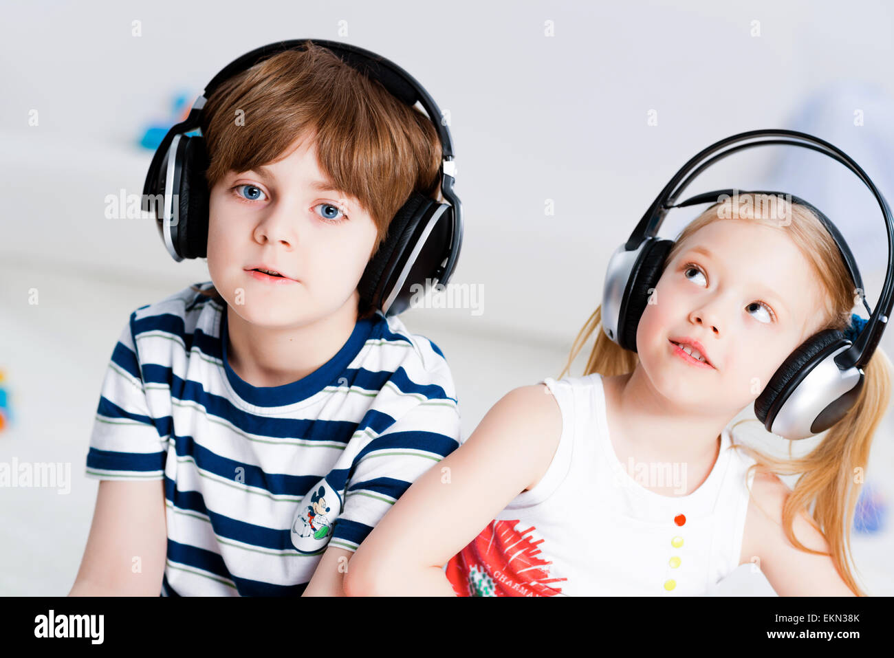 Brother and sister listening music with headphones Stock Photo