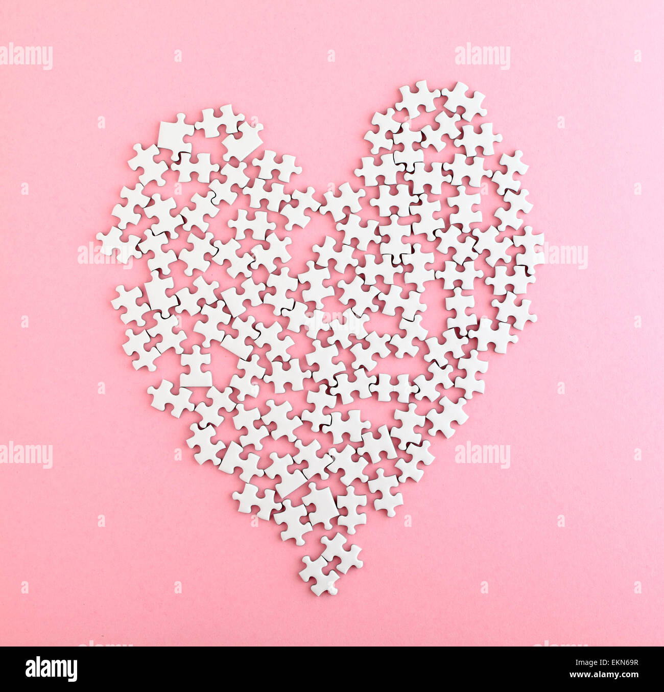 Puzzle made heart shape on pink background Stock Photo - Alamy
