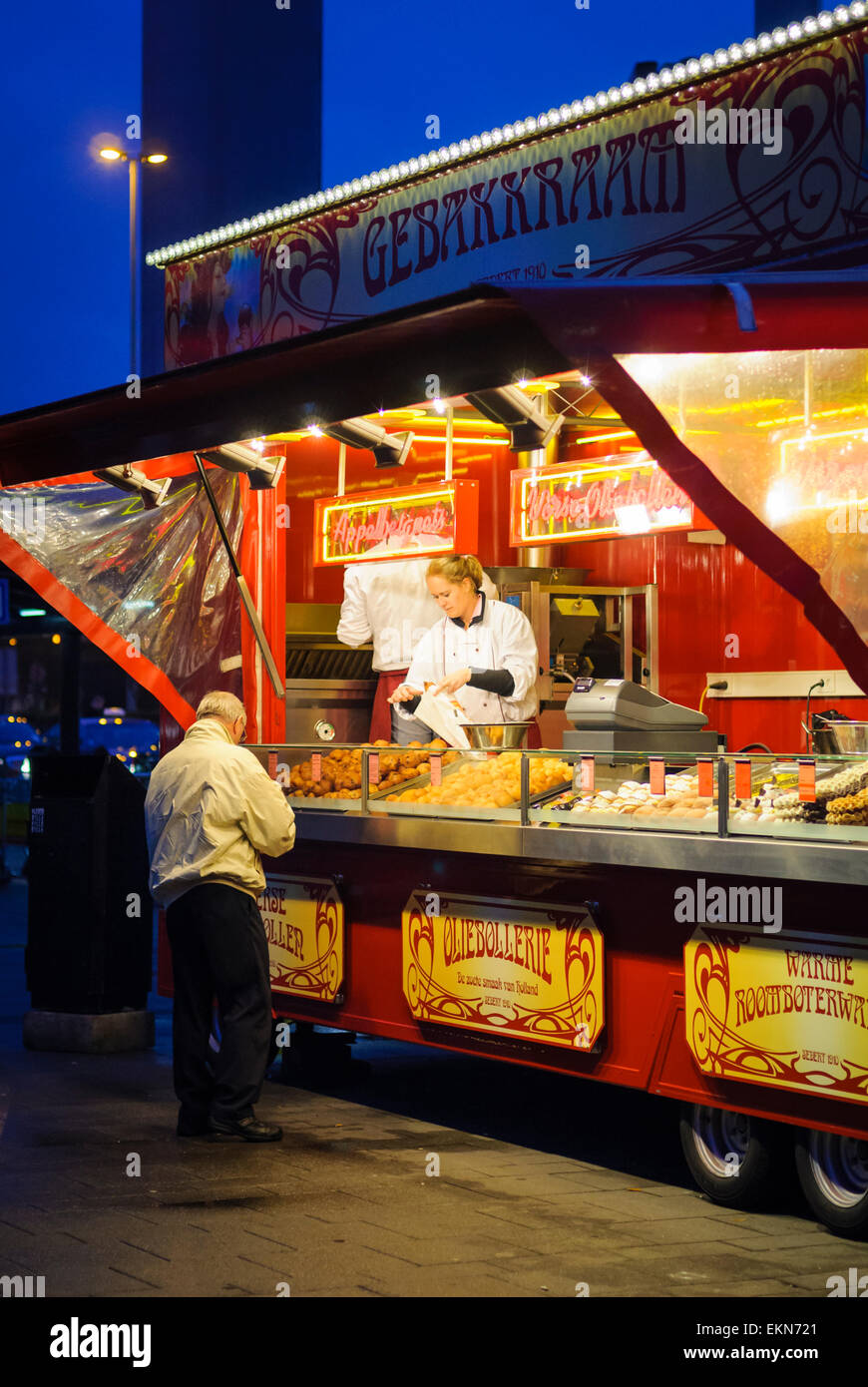 Snack stall at Amsterdam's Schiphol Airport, Holland, selling traditional Dutch food including waffles and pastries, in the evening. Food stand. Stock Photo