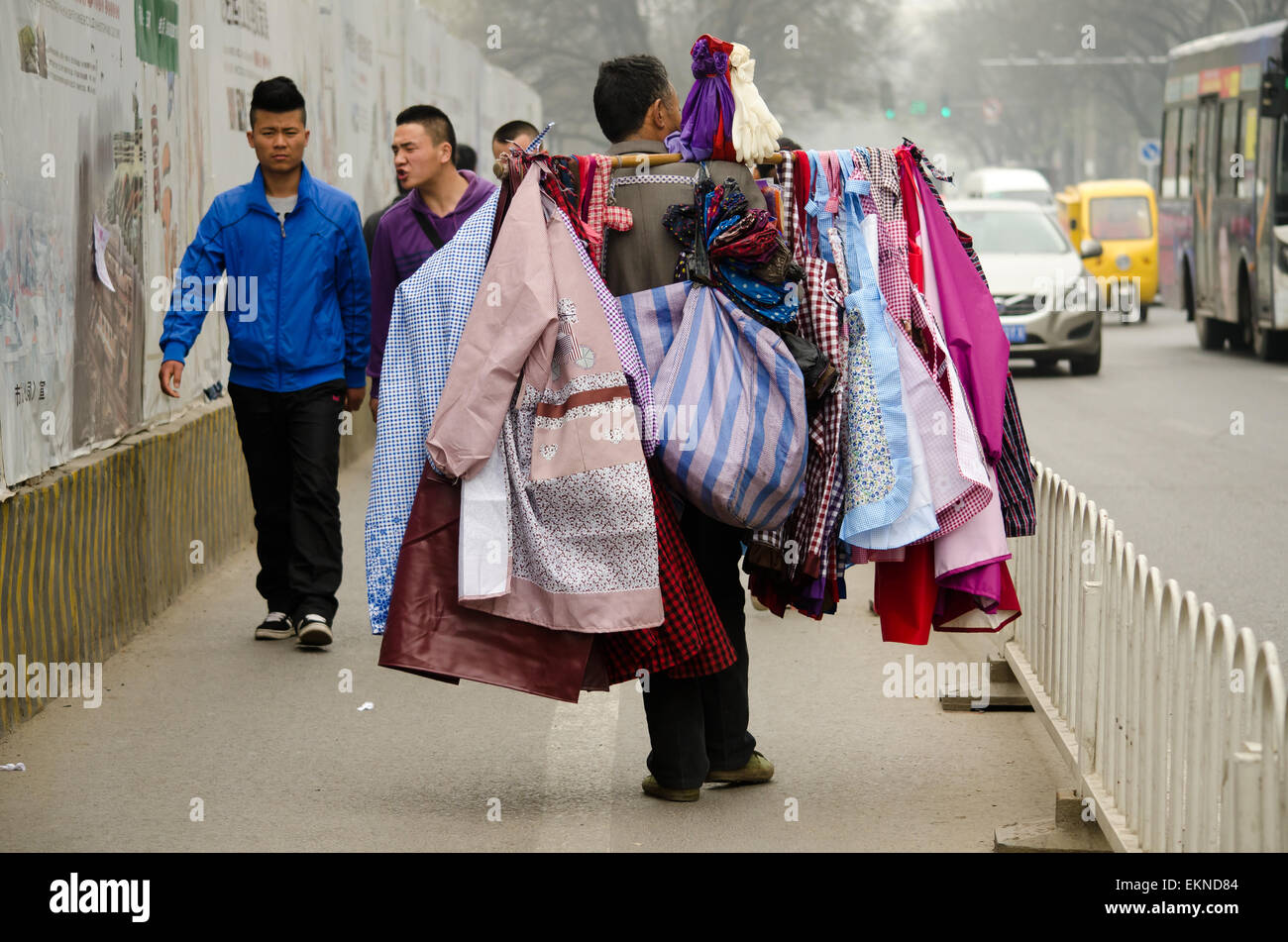 Old man walks the streets selling clothes and fabrics in Xi'an, China. Stock Photo