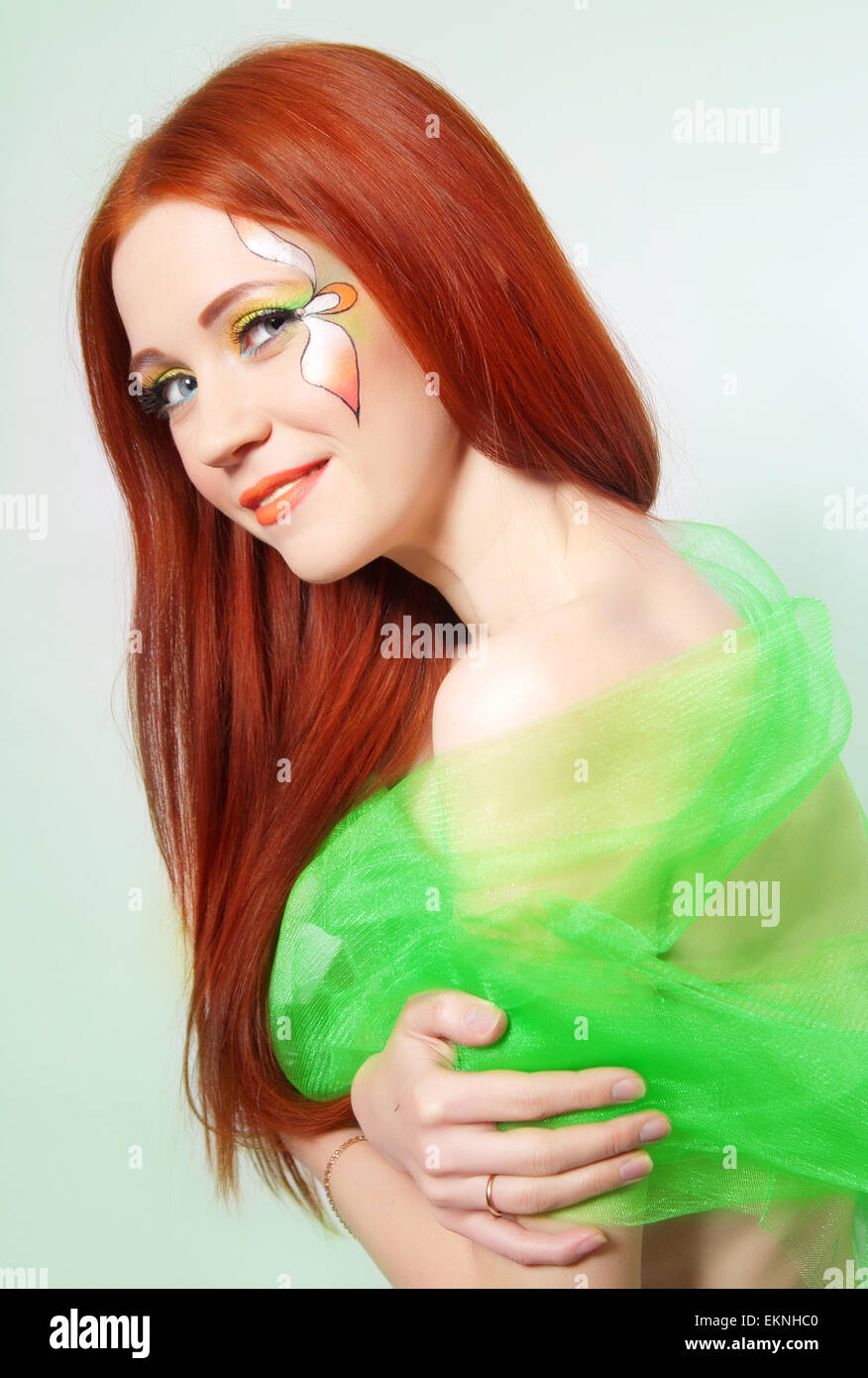 Portrait of beautiful red-haired girl with a flower painted on his face Stock Photo