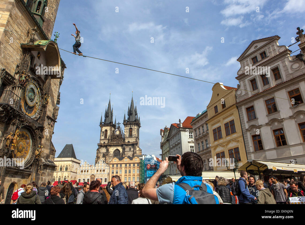 Tightrope walker on the lane in front of the Prague Astronomical Clock, Old Town Square Prague street show overhead Stock Photo