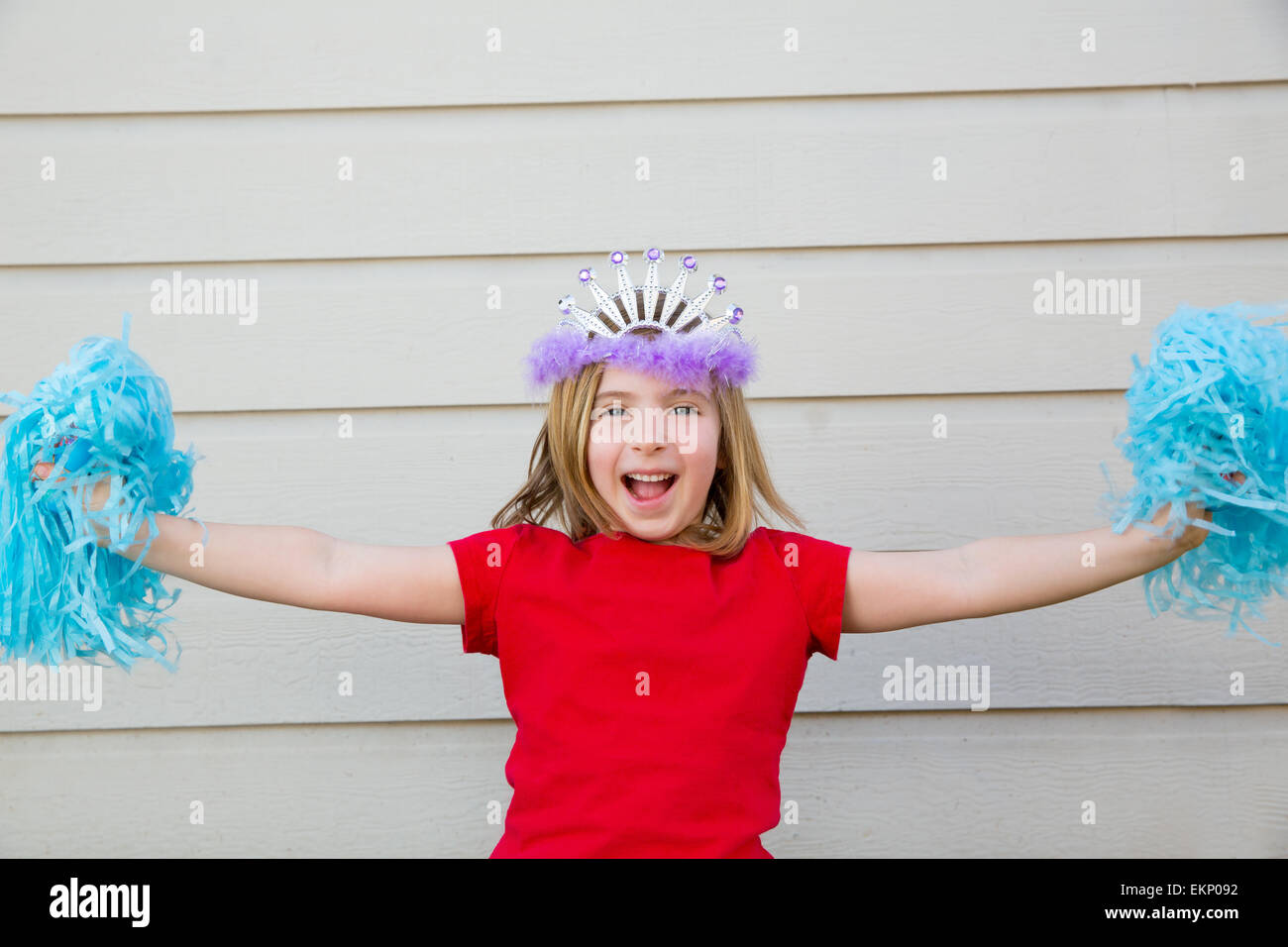 Blond kid girl playing like cheerleading pom poms and crown Stock Photo