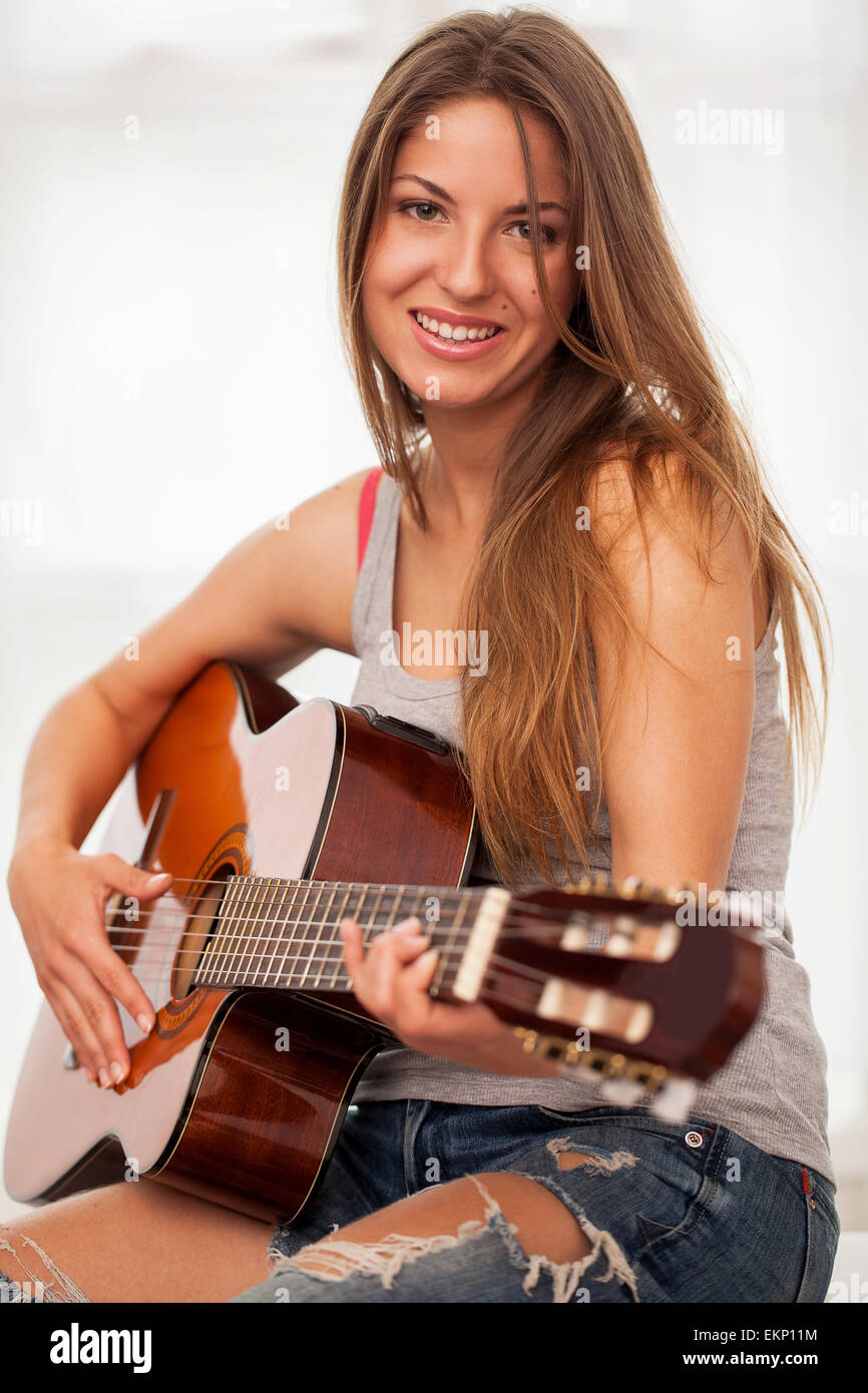 Young beautiful woman playing guitar Stock Photo - Alamy