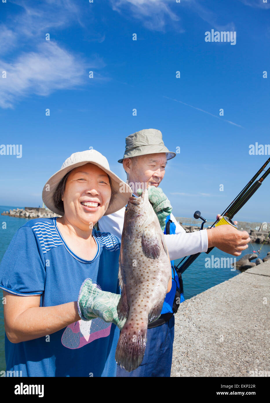 happy senior couple fishing and showing big grouper fish Stock Photo