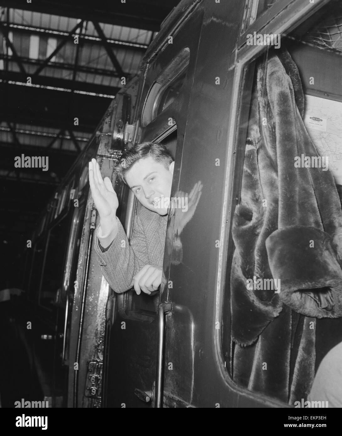 British pop singer Terry Dene waving from the train carriage window as he leaves for Winchester Barracks where he starts his two year service in the Army. 24th January 1959. Stock Photo