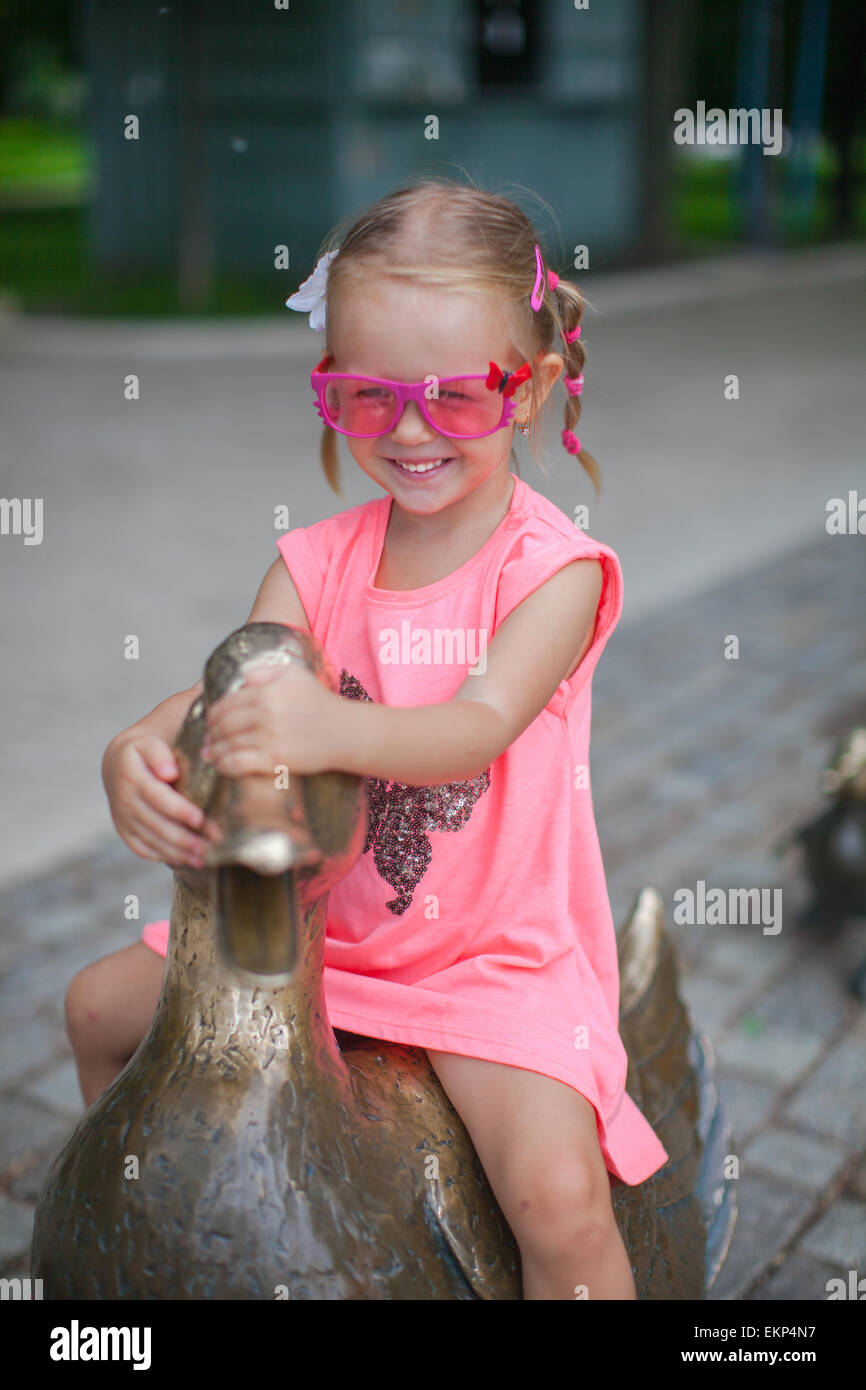 little girl astride on a duck figure of iron and having fun Stock Photo