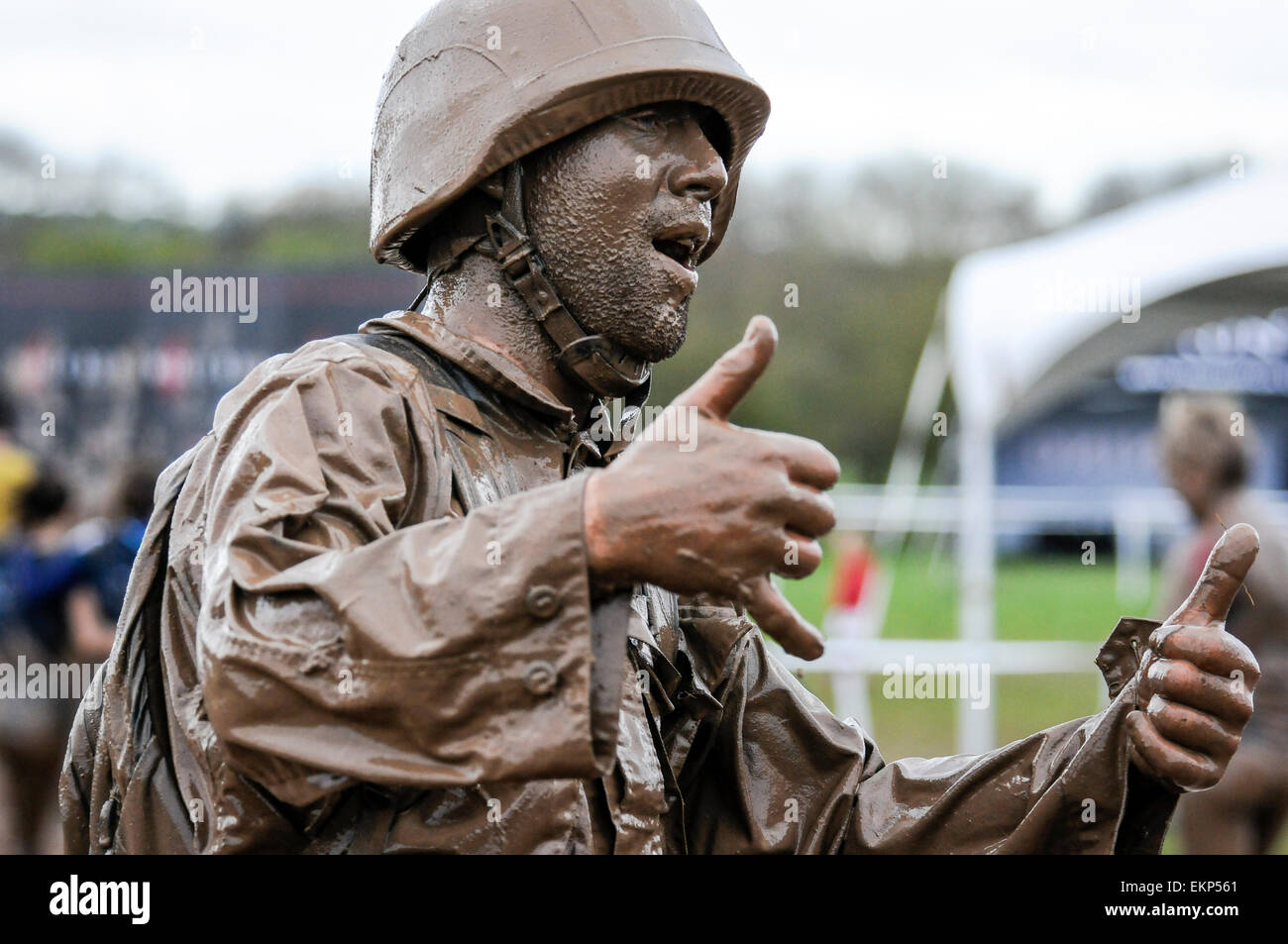 Soldier in full kit emerges from mud pool at finish line of an OCR