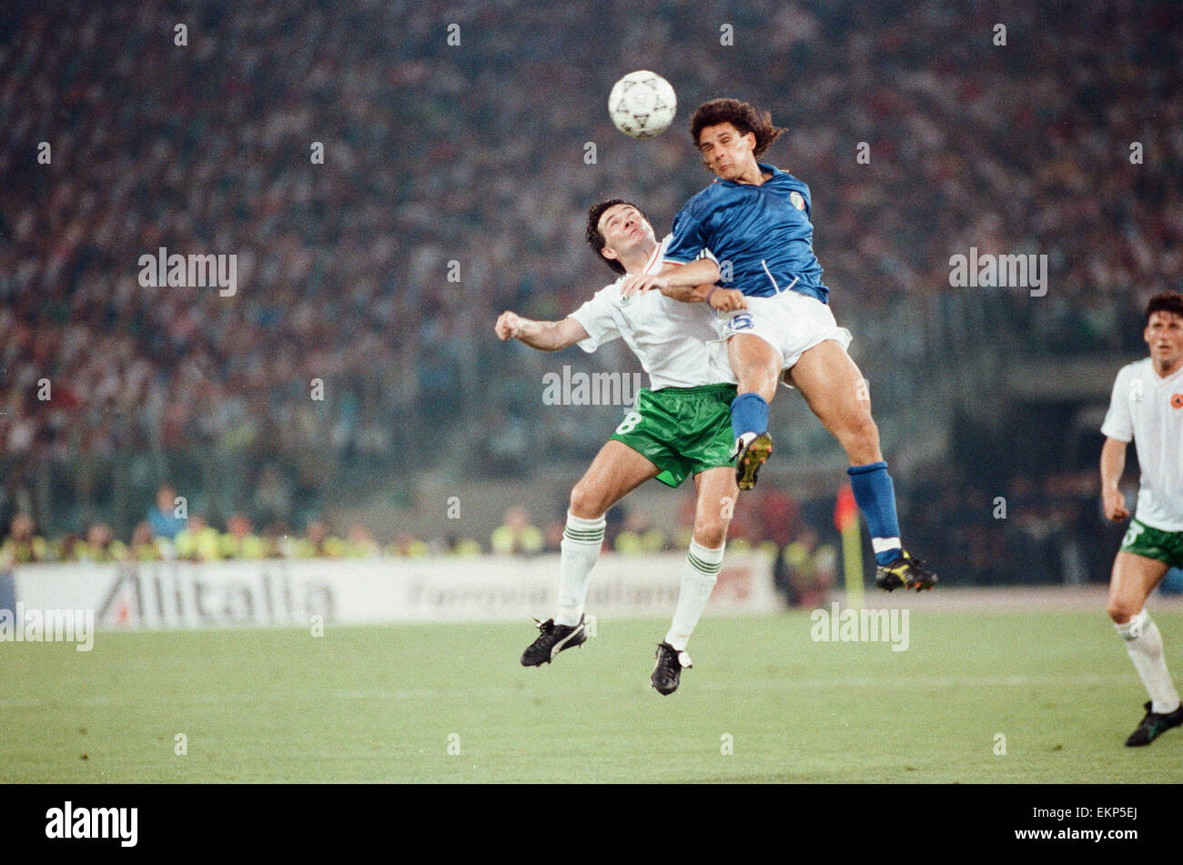 1990 World Cup Quarter Final match in Rome, Italy. Italy 1 v Republic of Ireland 0. Italy's Roberto Baggio jumps up for a high ball with Ray Houghton. 30th June 1990. Stock Photo