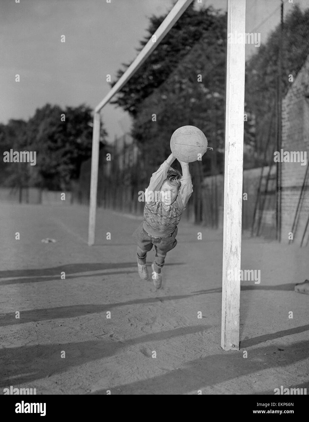 Ten year old George Welch makes a flying save while in goal for his school football team during a match at Kennington Park in London. 12th September 1952. Stock Photo